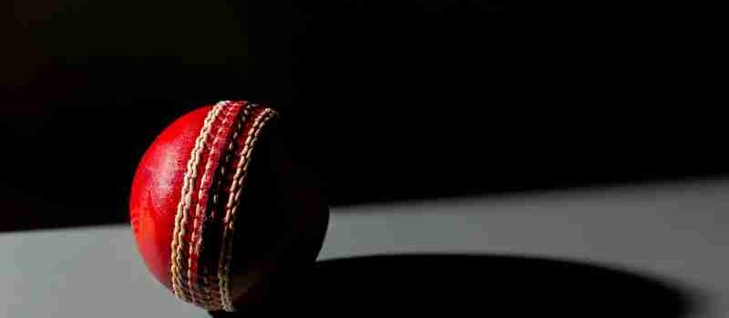 Dramatic image of a red cricket ball casting a shadow, highlighting texture and detail., tags: englands der - pexel